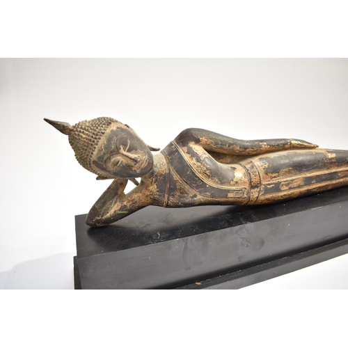 8631 - A Thai (Siam) gilded bronze reclining Buddha on associated plinth.  The gilding is extensively  worn... 