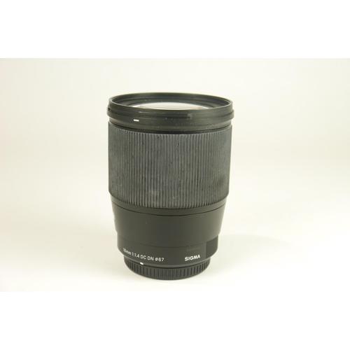 6051 - A Sigma 16mm F1.6 DC DN w/ Sigma lens hood LH716-01