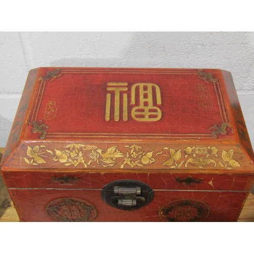 1038 - A Chinese influence red and gilt lacquered wooden jewellery box with mirrored interior and two drawe... 