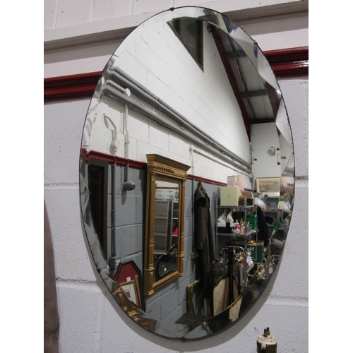 1042 - An oak framed oval wall mirror, bevelled glass, and another oval mirror (2)