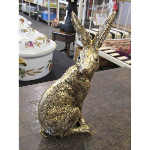 1046 - A resin bronze seated hare, 20cm tall