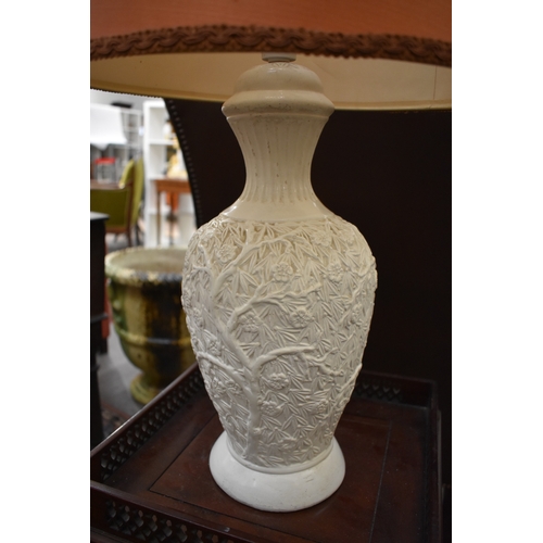 4043 - A ceramic lamp base with shade, the body decorated with blossoming tree and foliage, 71cm tall