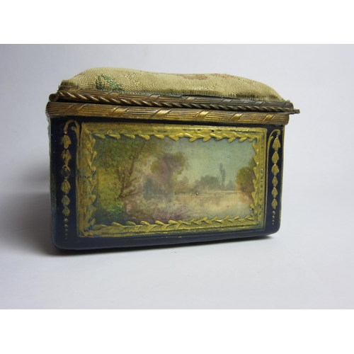 4430 - An enamelled trinket box, hand painted panels of landscapes, enriched with gilt, needlepoint lid