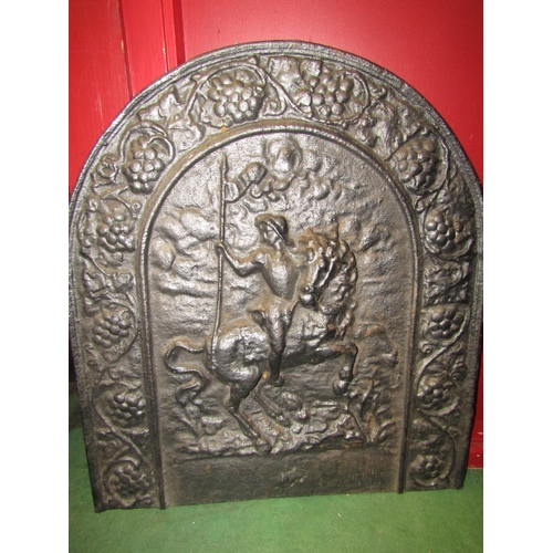 4027 - A cast iron arched fire back depicting horse and rider, grapevine border, 61cm x 55cm, and a fire ba... 