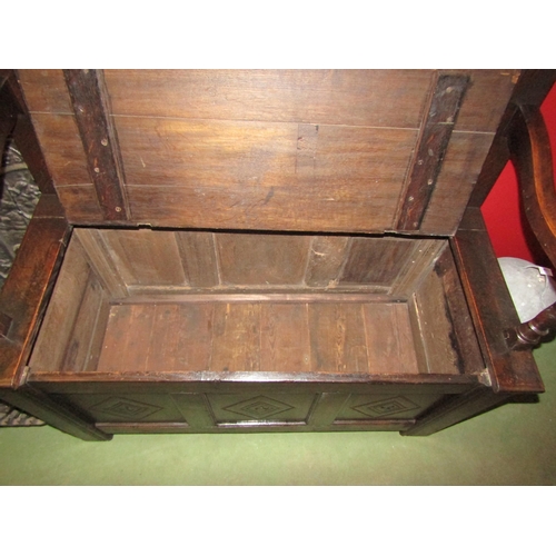 4030 - An 18th Century and later oak box seat hall bench the three panel backrest and base having carved lo... 