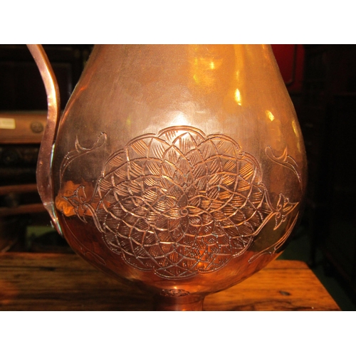 4155 - A French copper jug height 30cm (max) with floral engraving to the body and a patterned handle