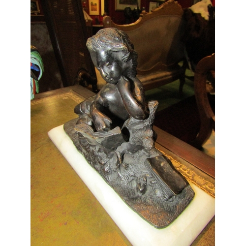 4229 - A bronze figure of a girl holding book on marble base, 17cm tall x 27cm long