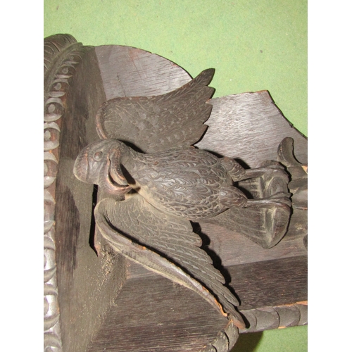 4265 - A Black Forest carved wood corner wall shelf with eagle design, 46cm tall