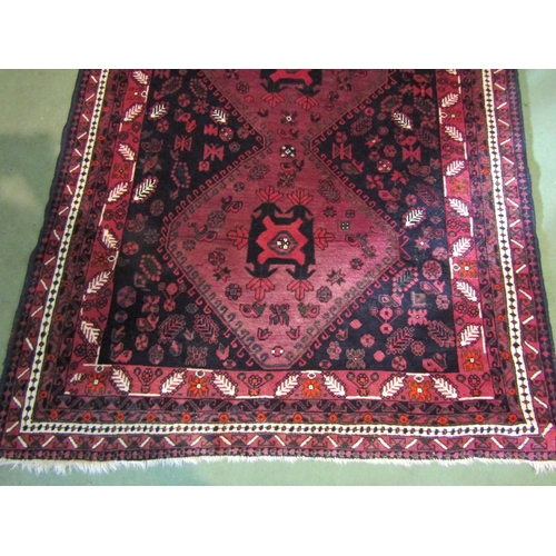 4556 - A Middle-Eastern wool rug, reds and blacks, foliate patterns, 250cm x 164cm