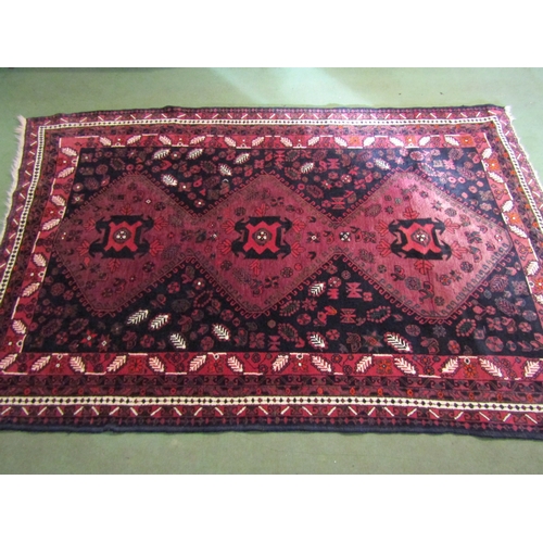 4556 - A Middle-Eastern wool rug, reds and blacks, foliate patterns, 250cm x 164cm