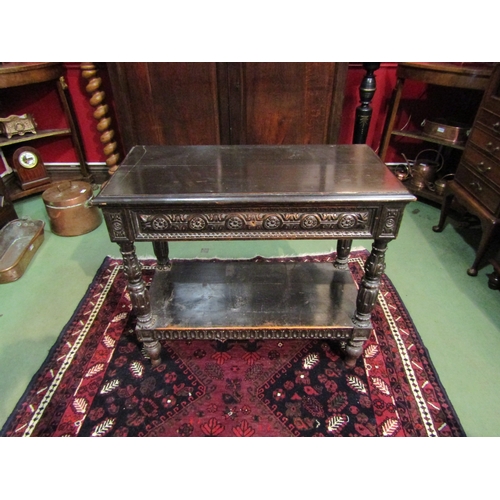 4071 - A 19th Century Jacobean style two-tier single drawer serving table, intricately carved frieze and su... 