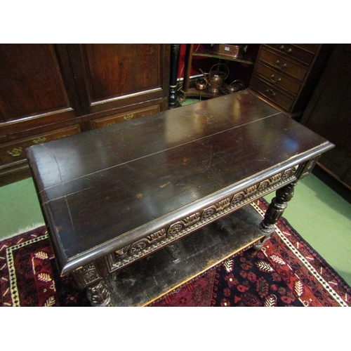 4071 - A 19th Century Jacobean style two-tier single drawer serving table, intricately carved frieze and su... 