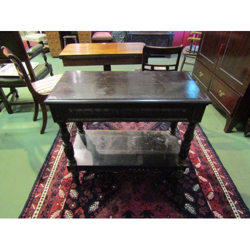 4071 - A 19th Century Jacobean style two-tier single drawer serving table, intricately carved frieze and su... 