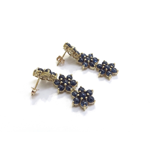 6028 - A pair of 9ct gold drop earrings comprising of three cabochon sapphire daisies, 3.6cm drop, 8.3g