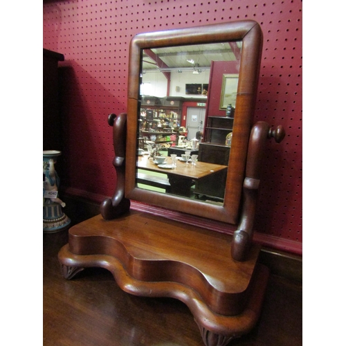 4039 - A mid-Victorian mahogany dressing chest tilting mirror on a serpentine front plateau base and carved... 