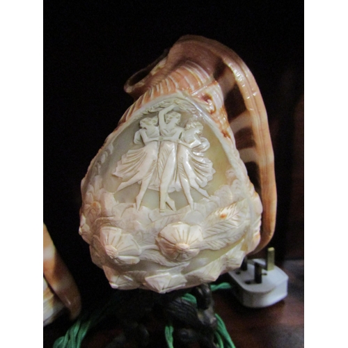 4063 - An ornately carved cameo conch shell table lamp and two shades