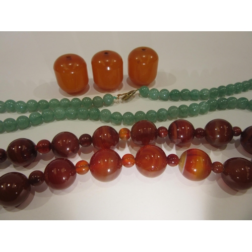 1336 - A cornelian bead necklace, three amber beads and a green quartz necklace