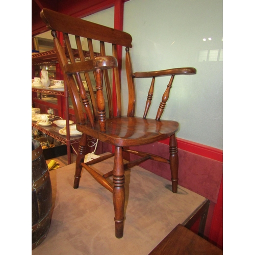 4009 - A late Victorian ash and elm seat lathe back farmhouse open armchair, the broad arms over a dished s... 