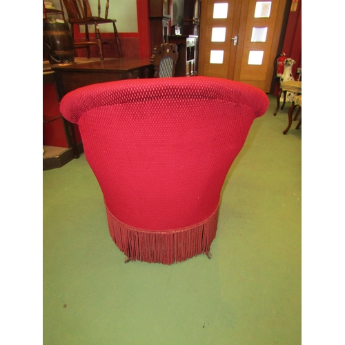 4011 - A late Victorian tub shape armchair with serpentine front seat and tassel fringe on ebonised legs an... 