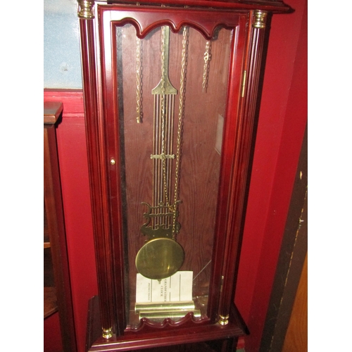 4025 - An Emperor mahogany longcase clock with two weights and a pendulum, atlas detail to face