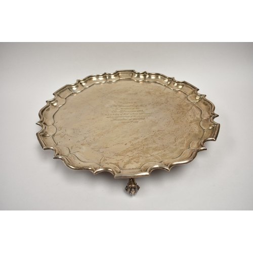 8032 - A Thomas Bradbury & Sons Ltd silver salver of piecrust edge form raised on three scroll feet with ce... 