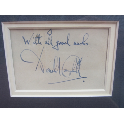 7065 - A framed and glazed collection of photographs of Donald and Malcom Campbell with a signed letter and... 