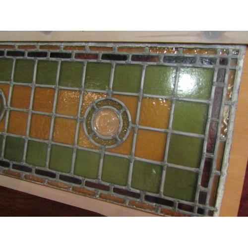 A leaded stained glass window panel with three bullseye roundels, red ...