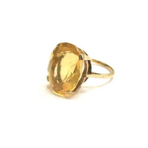 7257 - A gold ring stamped 9ct with a large oval citrine coloured stone, 17mm x 14mm. Size L/M, 5.4g