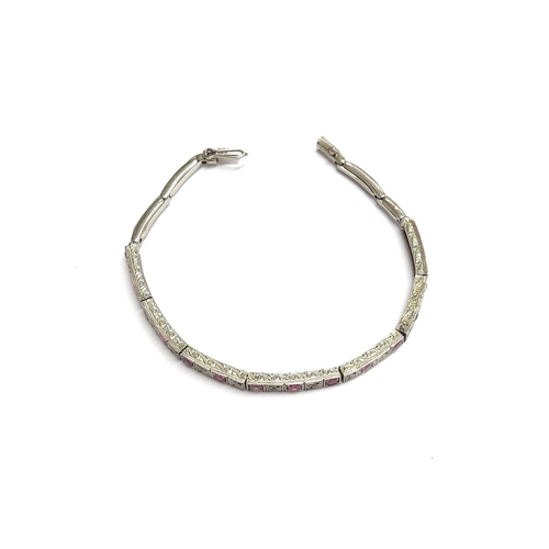 7053 - A white gold and ruby bracelet with seven links of two rubies  alternating with a milgrain panel, sp... 