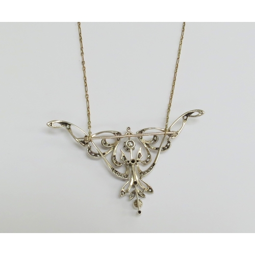 7034 - A diamond encrusted brooch/pendant in yellow and white metal with a single pearl to point, unmarked,... 