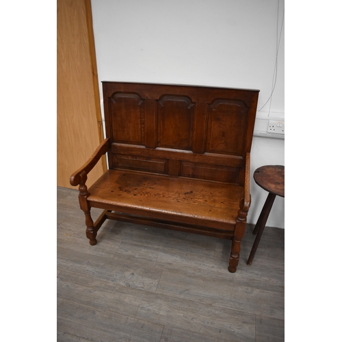 4176 - A 17th Century revival oak three panel back hall settle the scroll arms on turned supports united by... 
