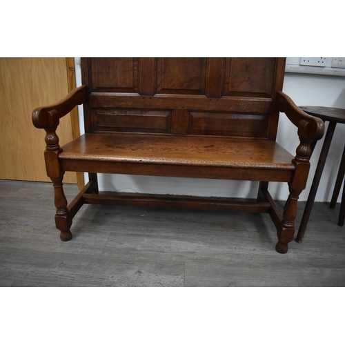 4176 - A 17th Century revival oak three panel back hall settle the scroll arms on turned supports united by... 