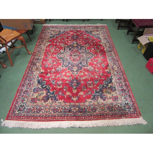 4381 - A large red and blue ground wool rug, central geometric panel and floral design with multiple border... 