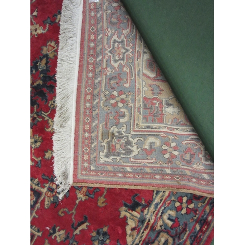 4381 - A large red and blue ground wool rug, central geometric panel and floral design with multiple border... 