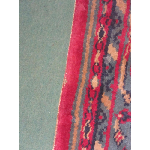 4381 - A large red and blue ground wool rug, central geometric panel and floral design with multiple border... 