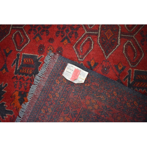 1024 - A Persian hand woven rug the central field decorated with various motifs including guls, flowers, st... 