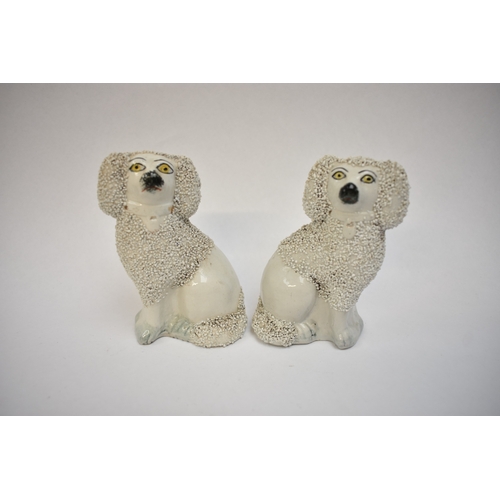 1051 - A pair of 19th Century Staffordshire poodles and two others, one holding a basket in its mouth, 12cm... 