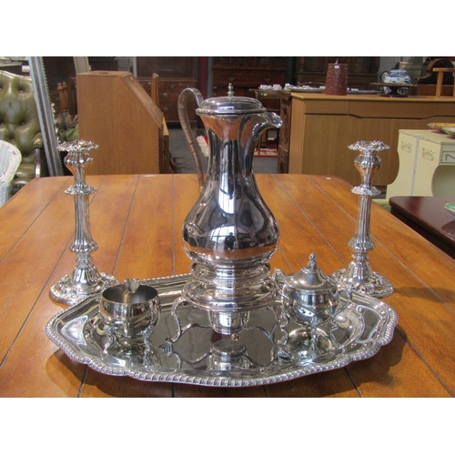 1002 - A selection of plated wares including hot water jug with spirit stove, teapot, coffee pot, milk and ... 