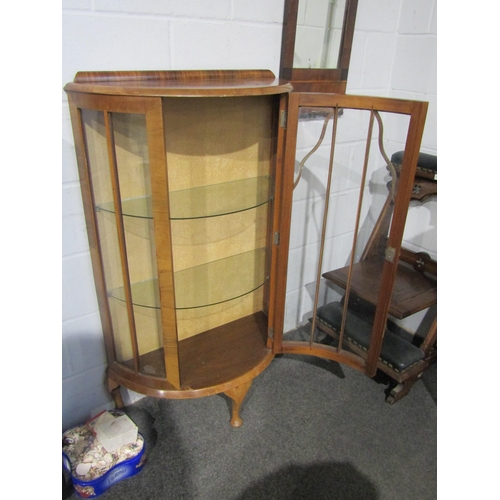 1010 - A 1940's bow fronted walnut veneer cabinet with glass shelves, 122cm tall x 74cm wide x 33cm deep