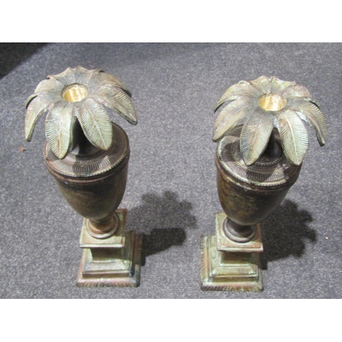 1041 - A pair of copper effect urn form candlesticks, 34cm tall