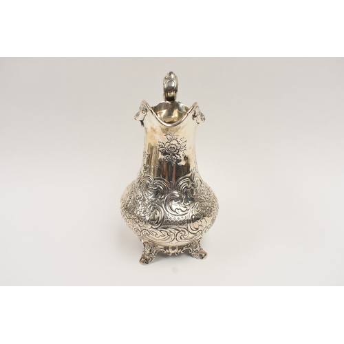 5019 - A William Hunter silver large milk jug with embossed floral and leaf detail, vacant cartouche, Londo... 