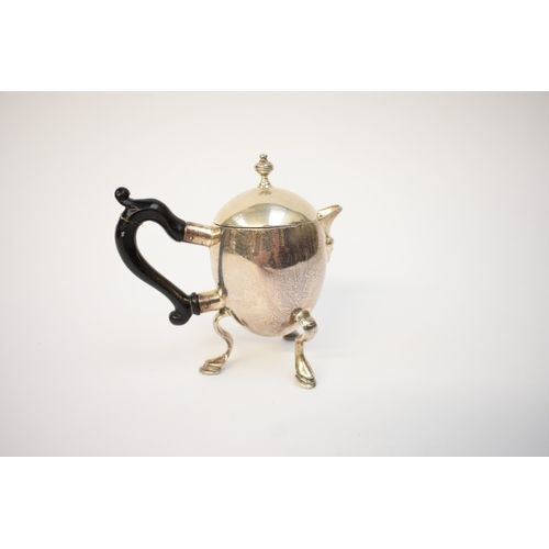 5054 - A Harry Freeman silver hot milk jug with detachable lid and treen handle (split and glued) raised on... 