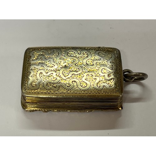 5112 - A William IV silver gilt vinaigrette fob, the foliate and floral edge with wavy and dappled engravin... 