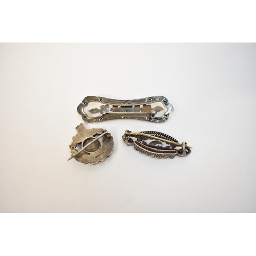 5117 - Three brooches, floral form and world.  Longest 6cm