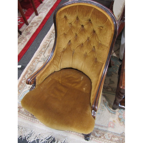 1023 - A rosewood button-back open armchair, golden upholstery, ceramic castors
