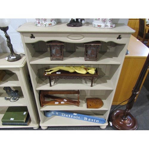 1031 - A painted four shelf bookcase on bun feet, 125cm tall x 87cm wide x 26cm deep