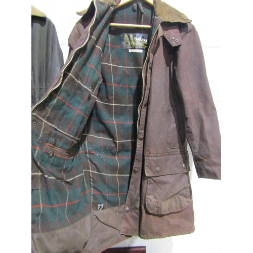 1052 - A Barbour Northumbria brown wax jacket with a smaller green example (Barbour size 10-12)