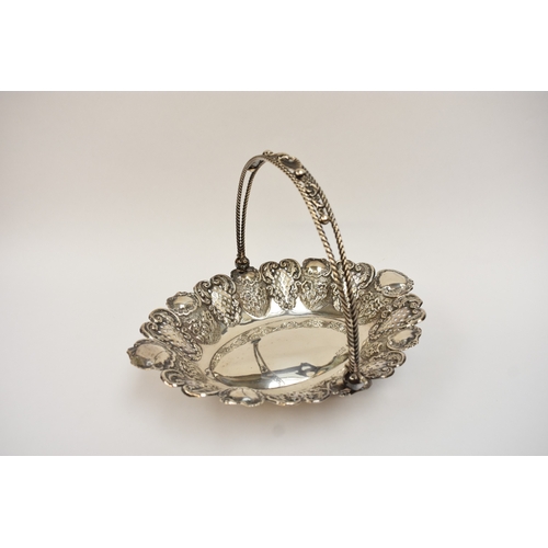 5007 - A silver swing handled basket with pierced panels, floral and shell decoration, raised on four ball ... 