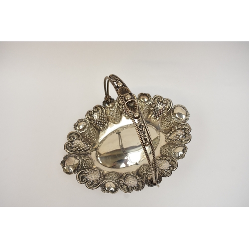 5007 - A silver swing handled basket with pierced panels, floral and shell decoration, raised on four ball ... 