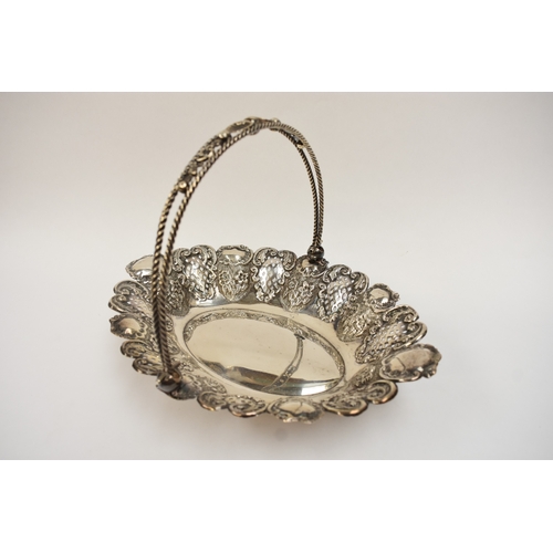 5007 - A silver swing handled basket with pierced panels, floral and shell decoration, raised on four ball ... 